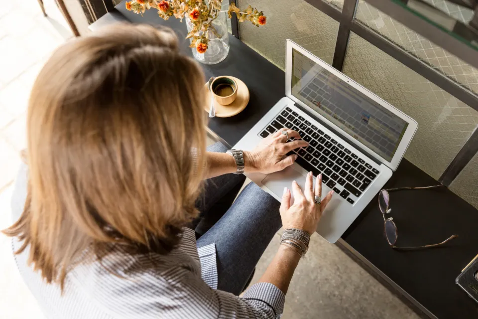 Frau tippt konzentriert an einem Laptop